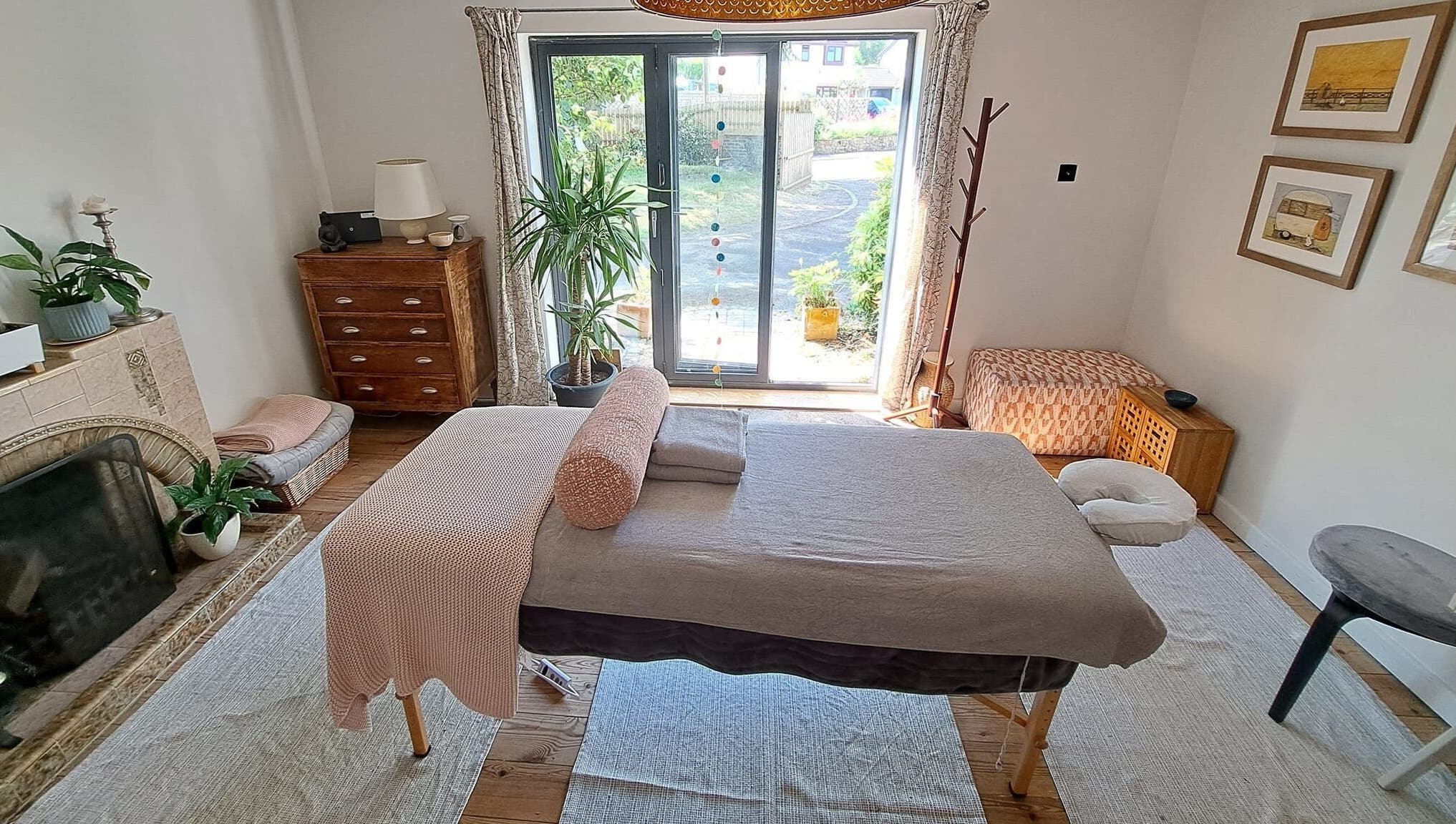 Relaxing massage room at The Cedar Room, Cullompton, England, GB, featuring a cozy setup and natural light.