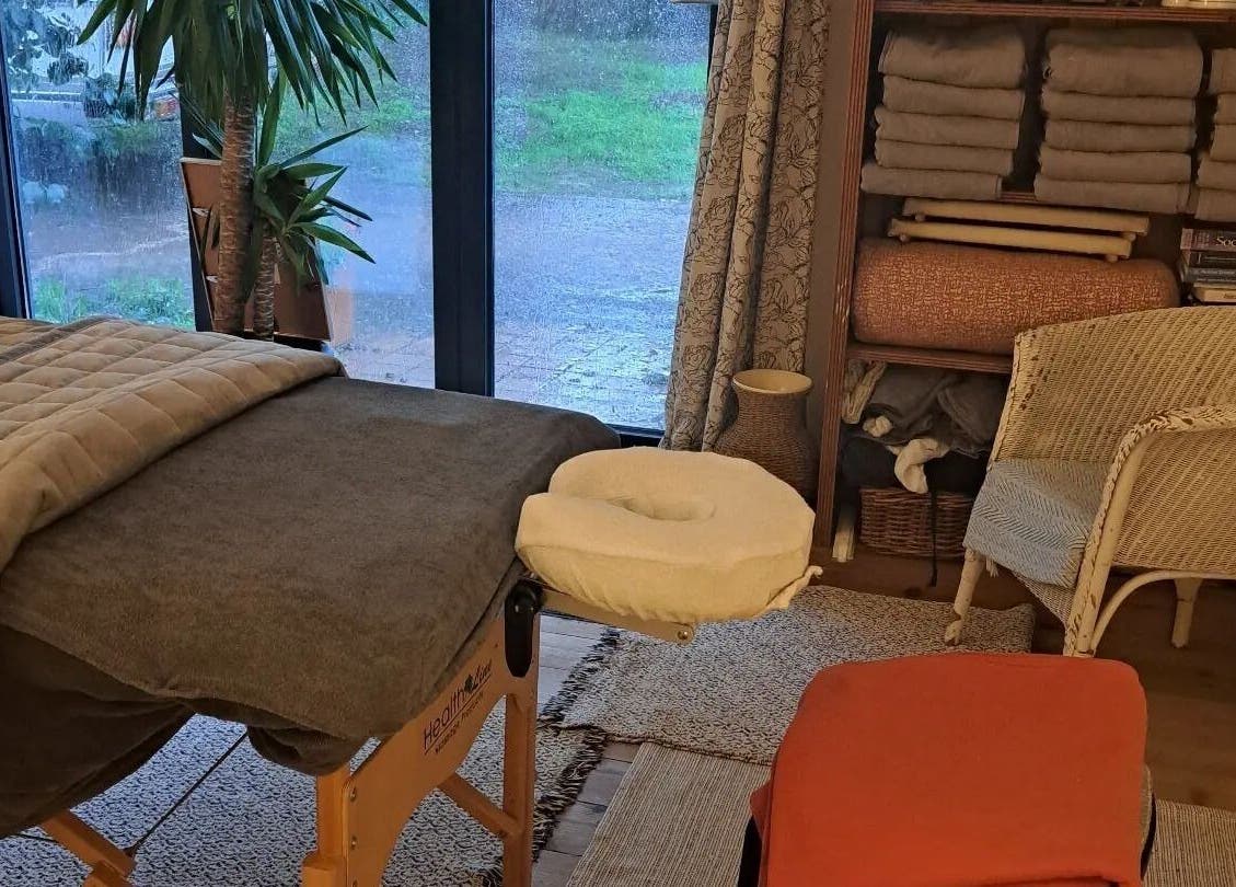 Serene massage room at The Cedar Room, Cullompton, England, GB featuring a cozy massage table and tranquil decor.