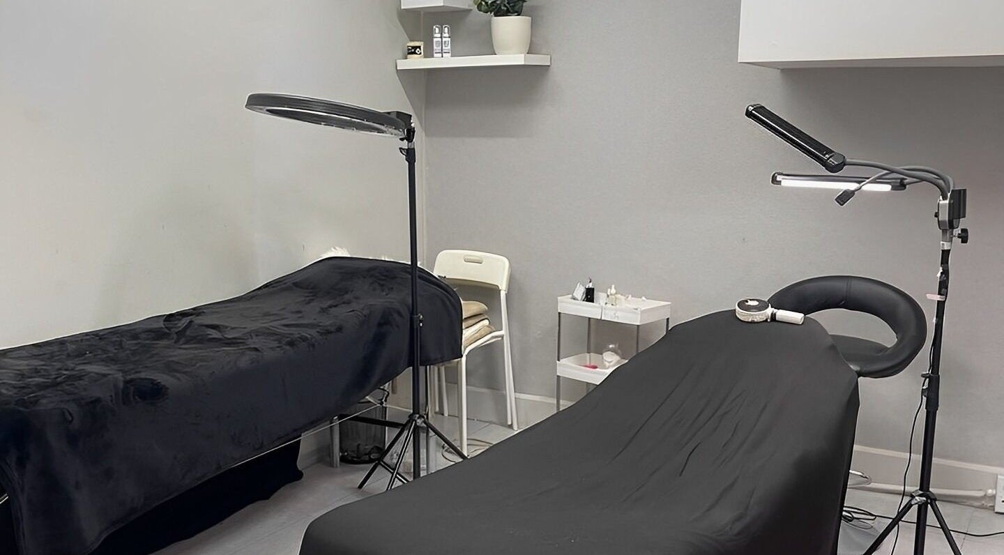 Eyelash treatment room at Bold & Beauty Eyelash Bar, Sandton, Gauteng, ZA with two massage chairs and lighting.