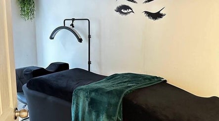 Relaxing treatment room at Selfie Lounge, London, England, GB with a sleek black couch and vibrant green blanket.