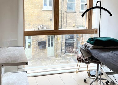 Well-lit treatment room at Selfie Lounge, London, England, GB with a therapy bed and large window.