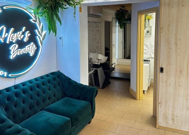 Elegant teal sofa and neon sign at Selfie Lounge, London, England, GB, enhancing beauty and wellness ambiance.
