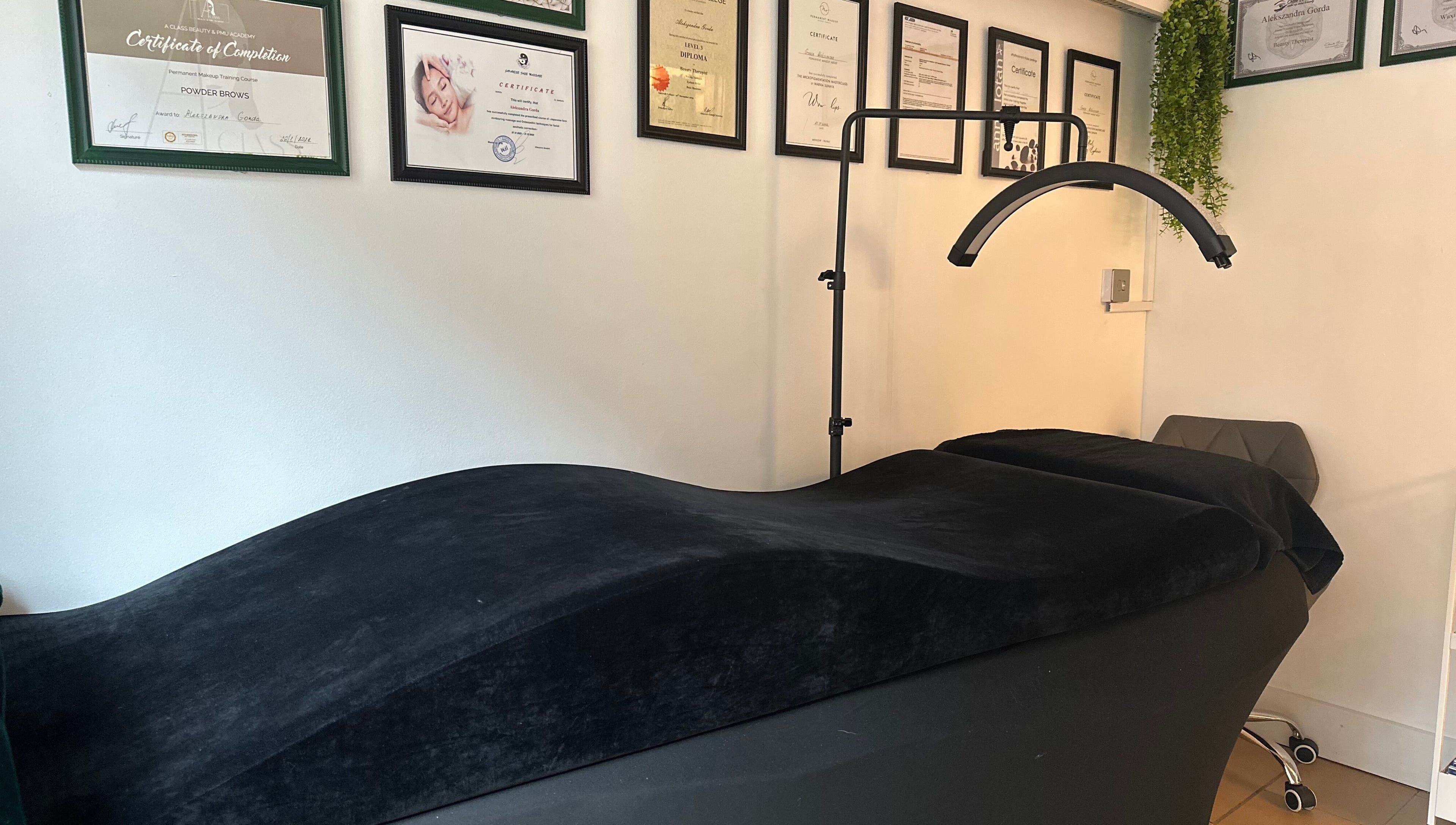 Sleek treatment bed at ABeauty's, Alexis with certificates on wall in London, England, GB.