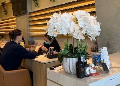 Luxurious manicure session at iNail Spa, Mentone, Victoria, AU, with chic decor and vibrant orchids displayed.