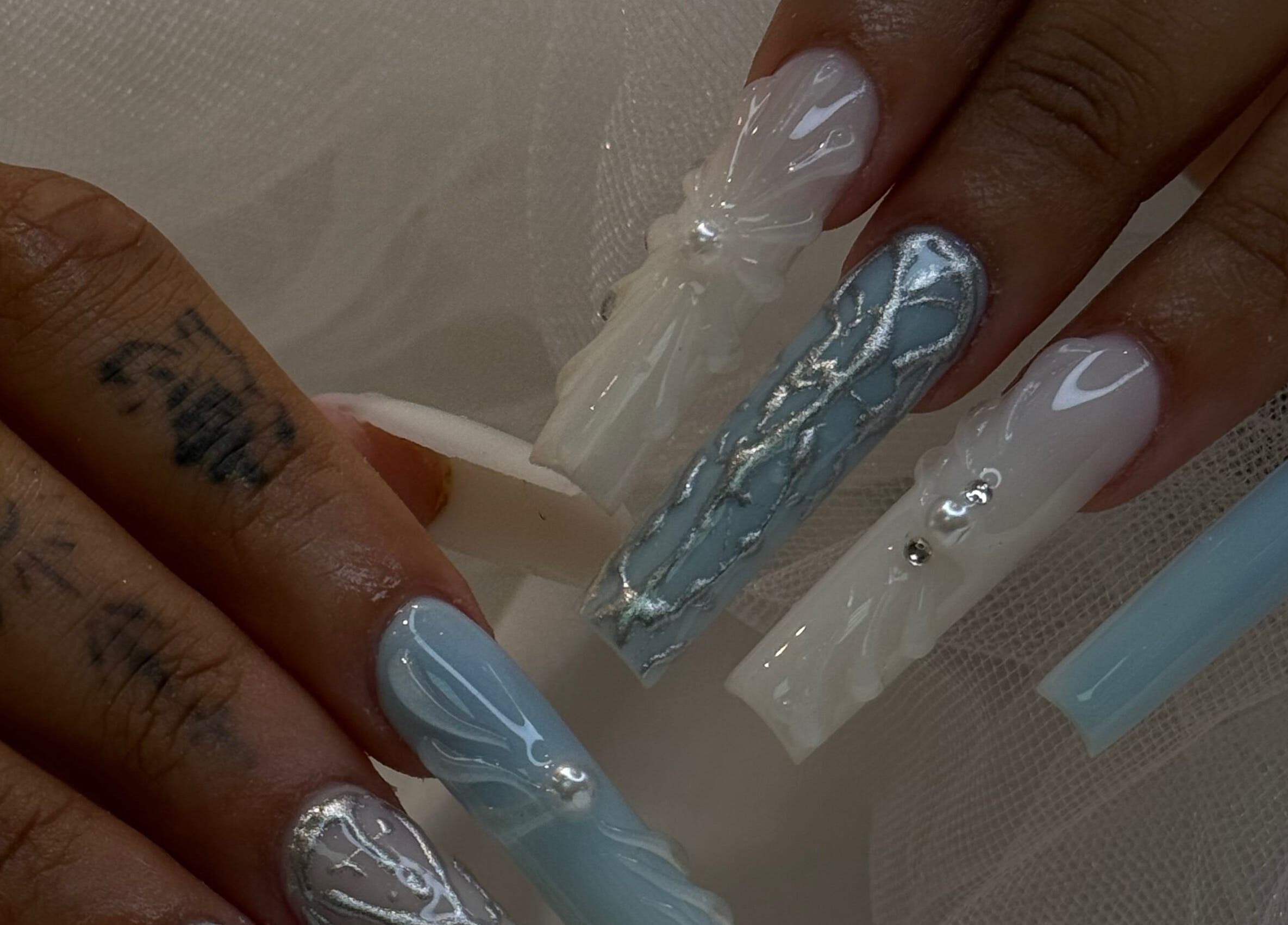 Intricate blue and white nail art at iNail Spa, Mentone, Victoria, AU showcasing detailed designs.