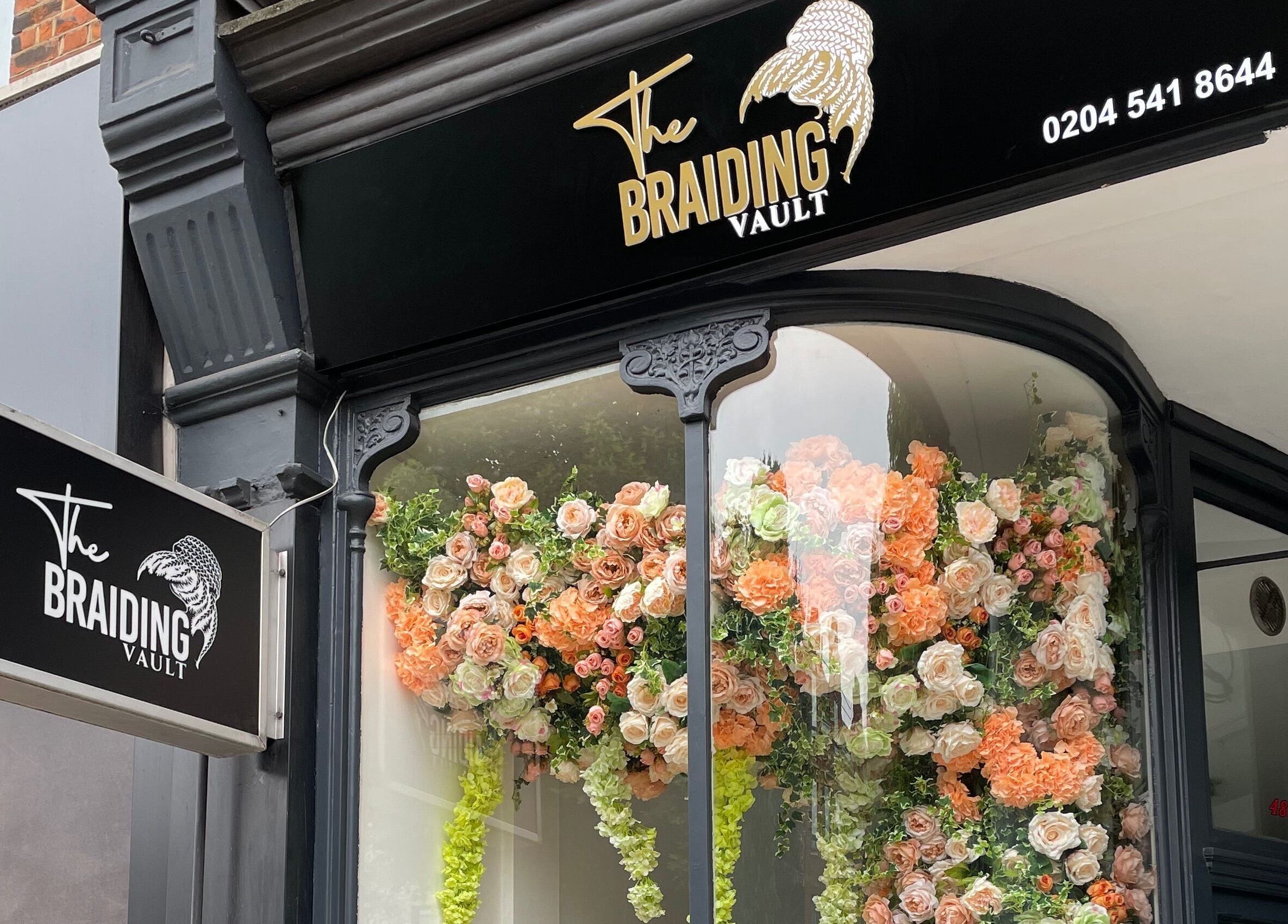 The Braiding Vault Uk storefront with vibrant floral display in London, England, GB.