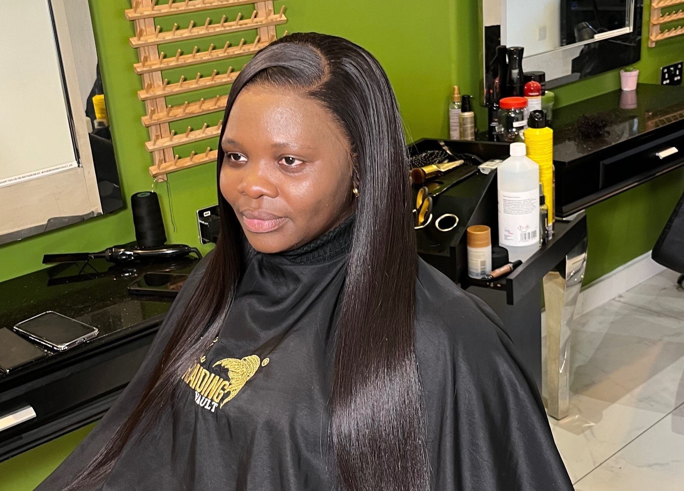 Client with sleek hair at The Braiding Vault UK, London, England, GB, showcasing hairstyling services.