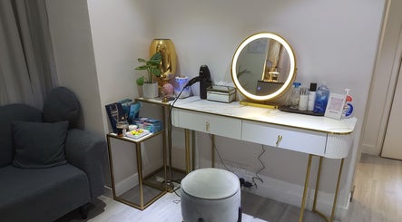 A chic vanity at Mima Skin at TST, 尖沙咀多福大廈2樓A室, HK, featuring a mirror, stool, and beauty products.