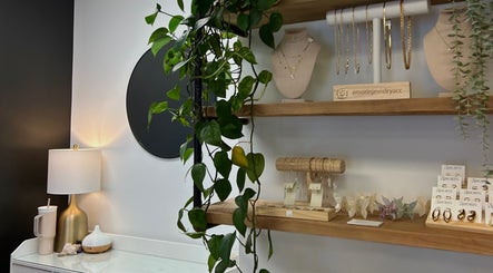 Elegant jewelry display shelves at Xoéy Nail Artistry, St. Albert, Alberta, CA featuring hanging plants and accessories.