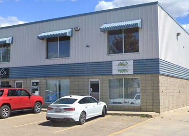 Exterior view of Xoéy Nail Artistry in St. Albert, Alberta, CA, showcasing a modern building with parked cars.