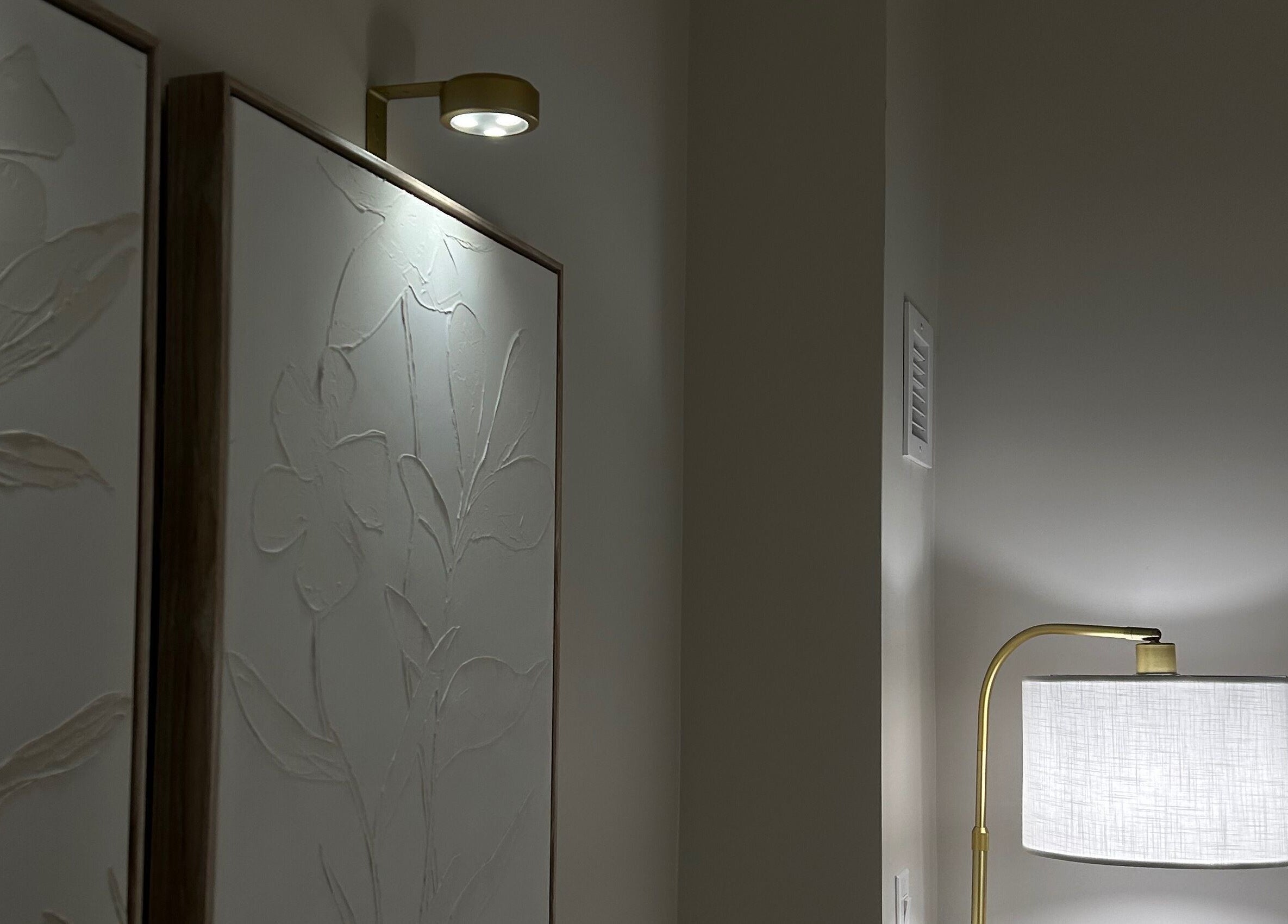 Warm lighting and textured art create elegant ambiance at Xoéy Nail Artistry in St. Albert, Alberta, CA.