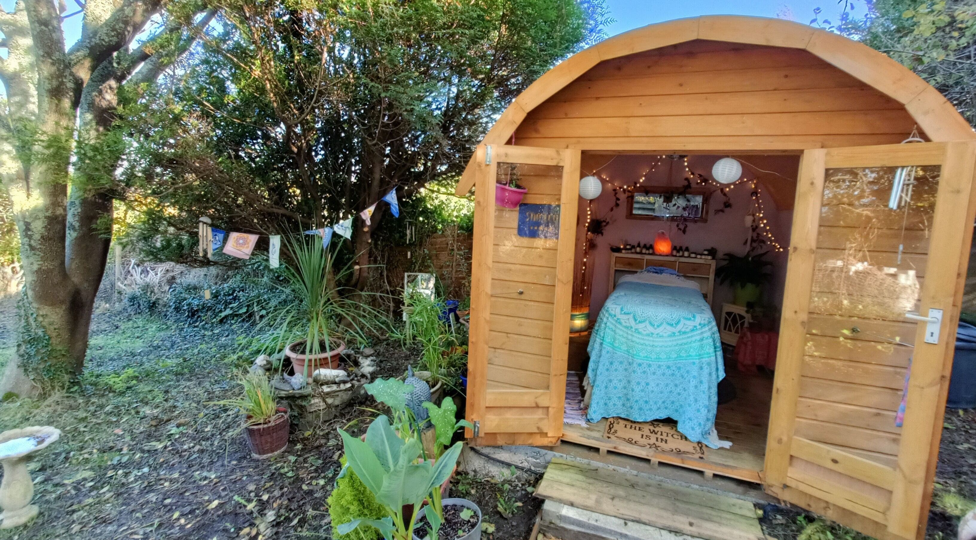 Rustic therapy cabin at Hayle Cornish Holistic Therapies in Hayle, GB, surrounded by lush greenery.