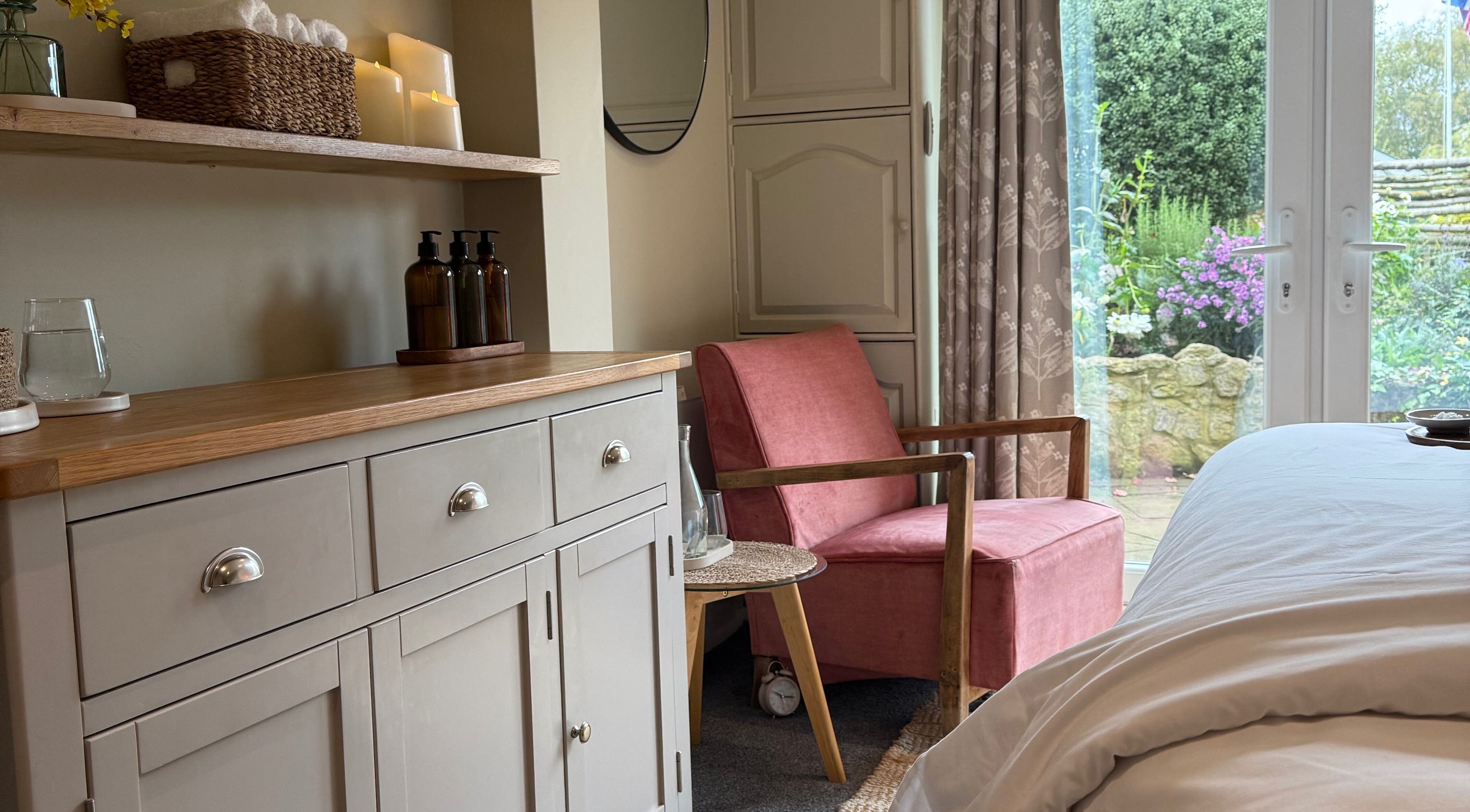 Elegant spa room at Apollonia Beauty, Kennington, England, GB with pink chair and garden view.