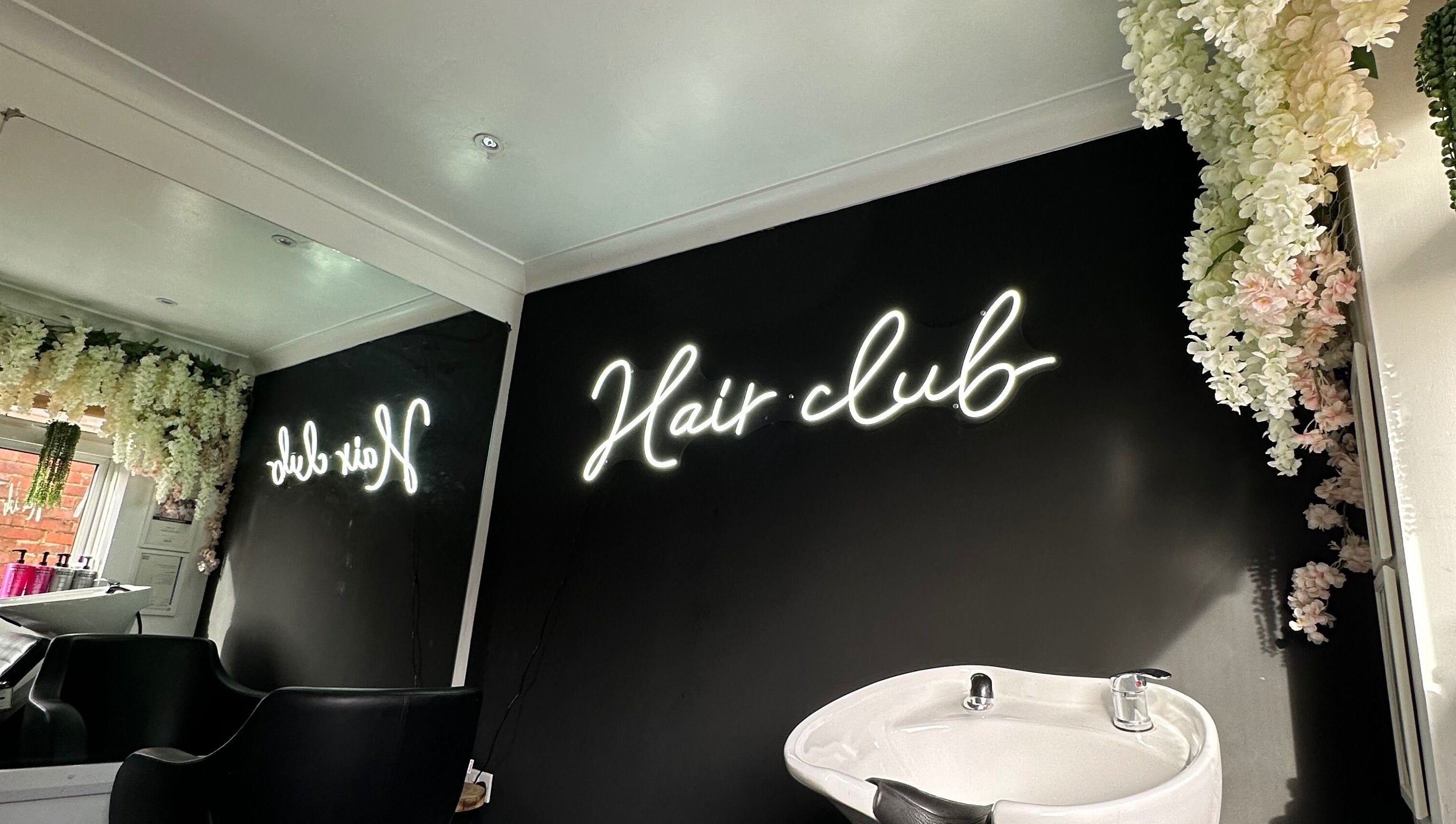 Stylish interior of The Hair Club, Waterlooville, England, GB with neon sign and elegant decor.