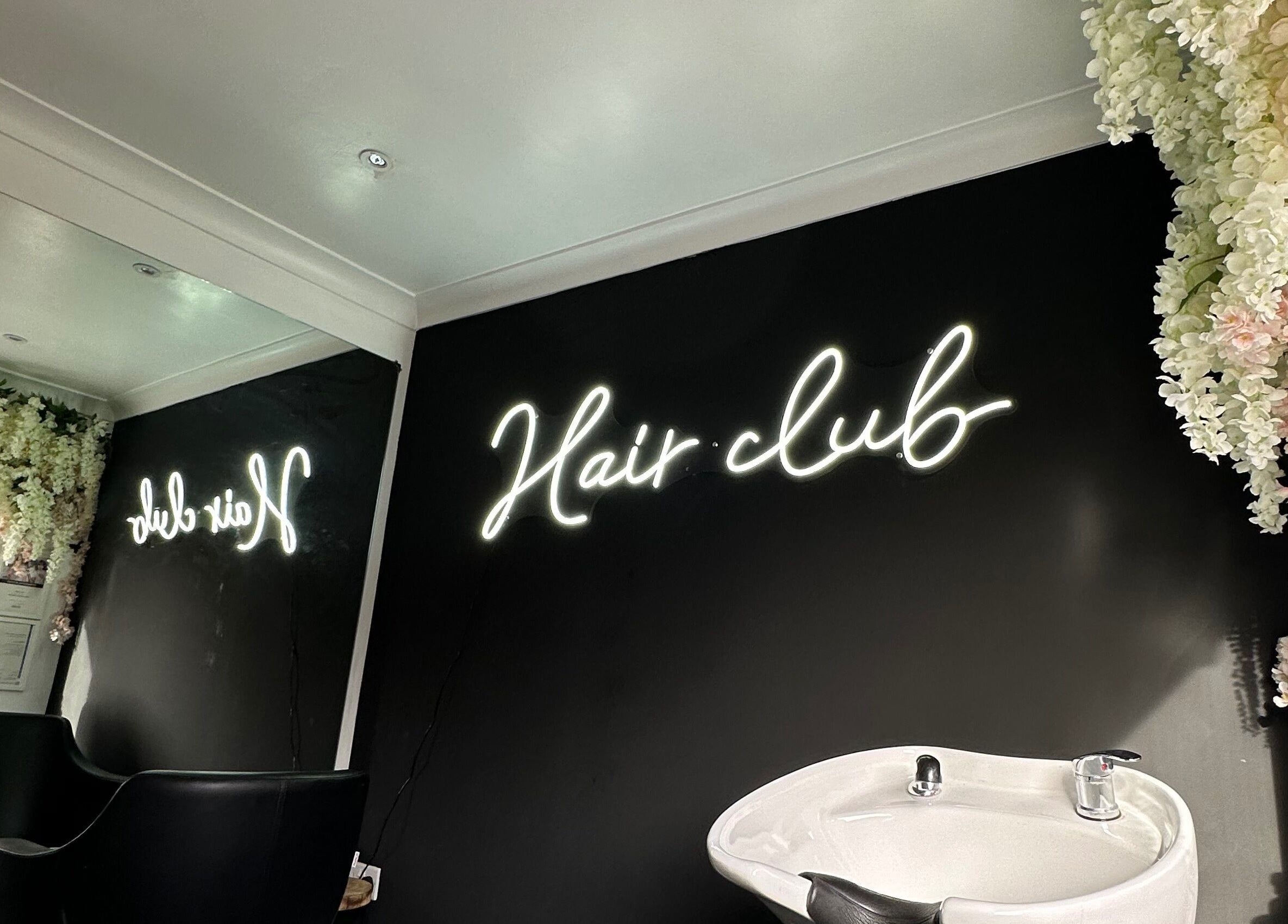 Stylish interior of The Hair Club, Waterlooville, England, GB with neon sign and elegant decor.