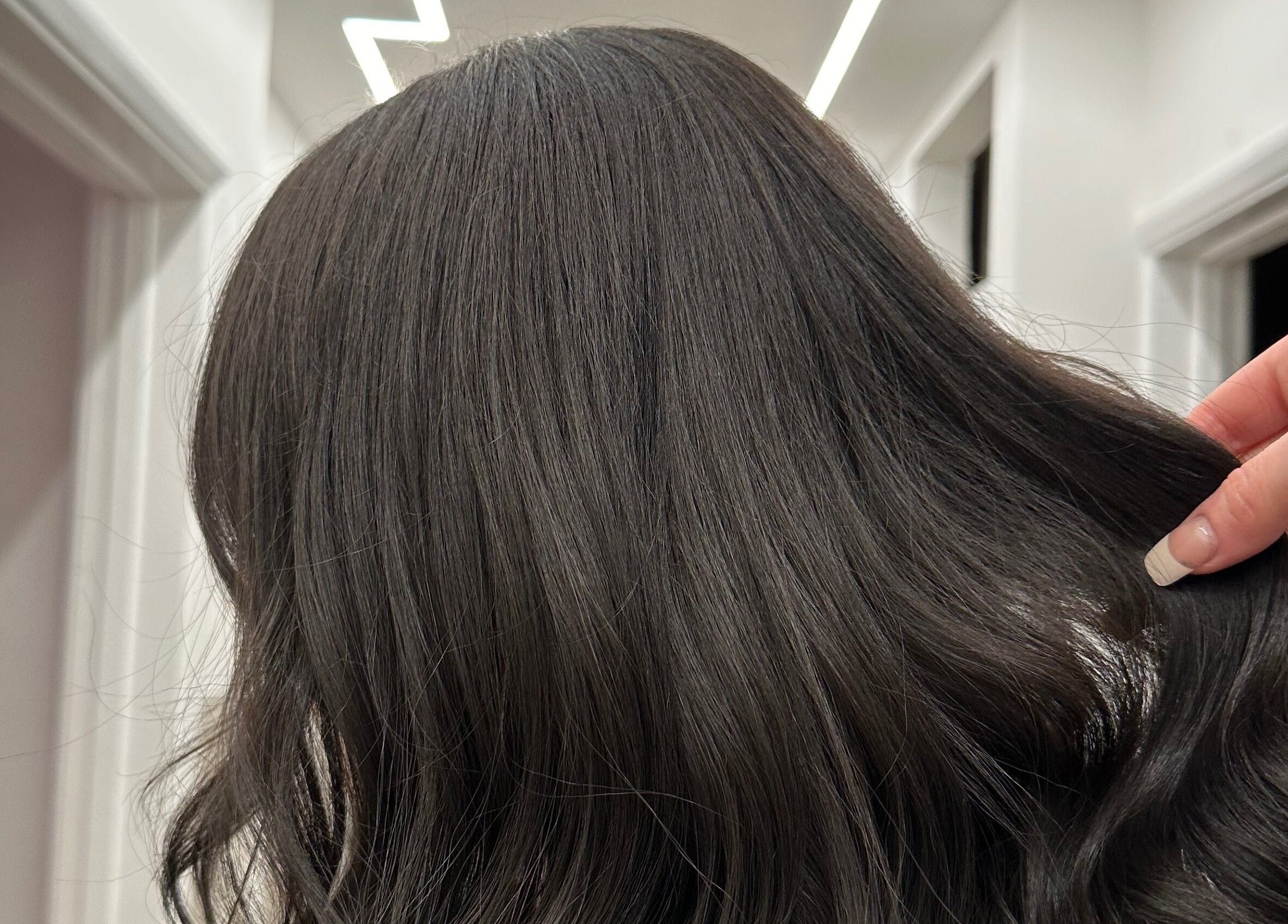 Luxurious dark hair at The Hair Club, Waterlooville, England. Perfectly styled wavy locks in an elegant salon setting.