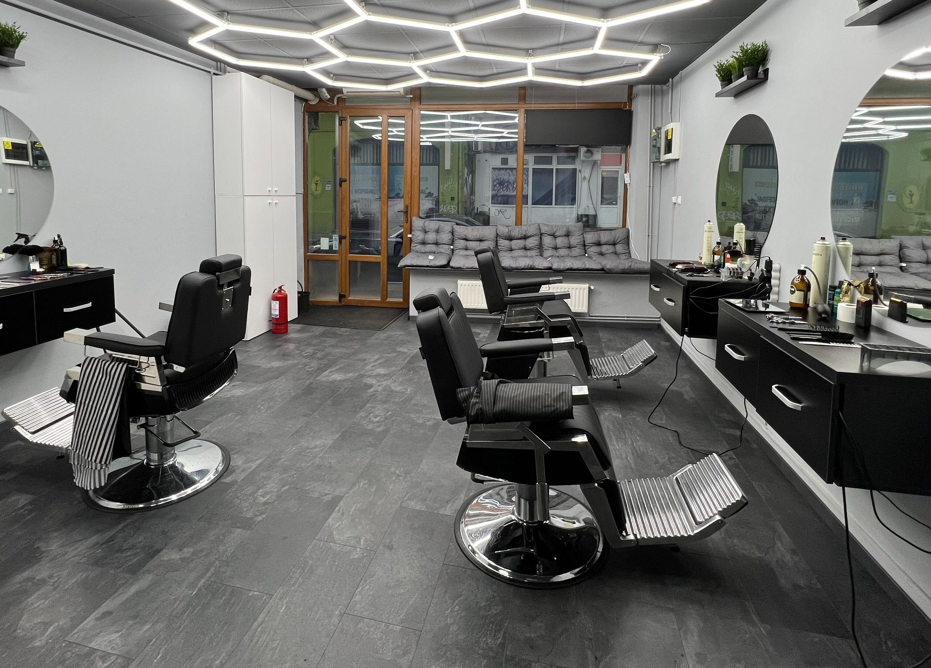 Interiorul modern al Damoti Barbershop din București, București, RO, cu scaune și oglinzi elegante.
