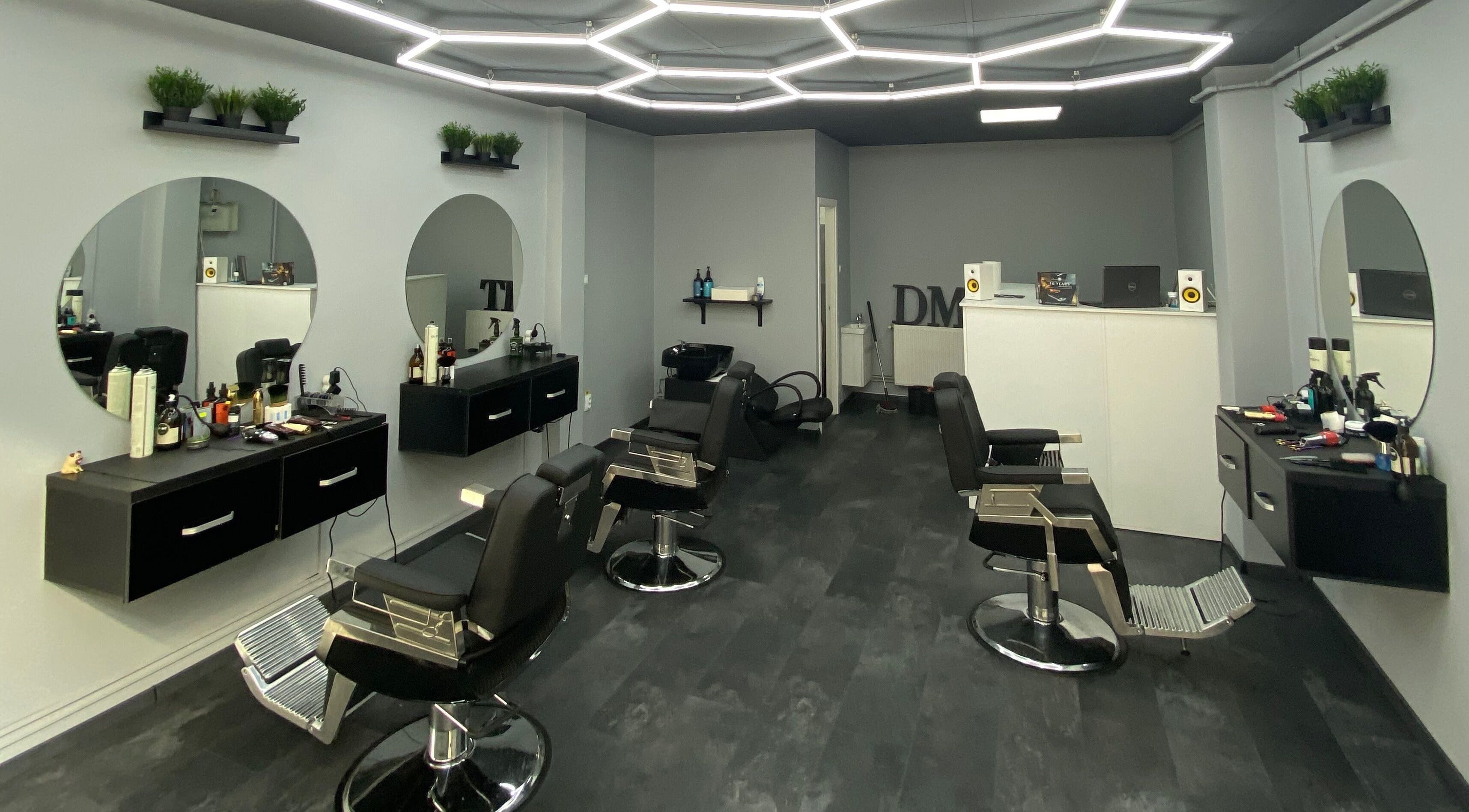 Interior modern și elegant la Damoti Barbershop, București, București, RO, cu oglinzi rotunde și scaune confortabile.