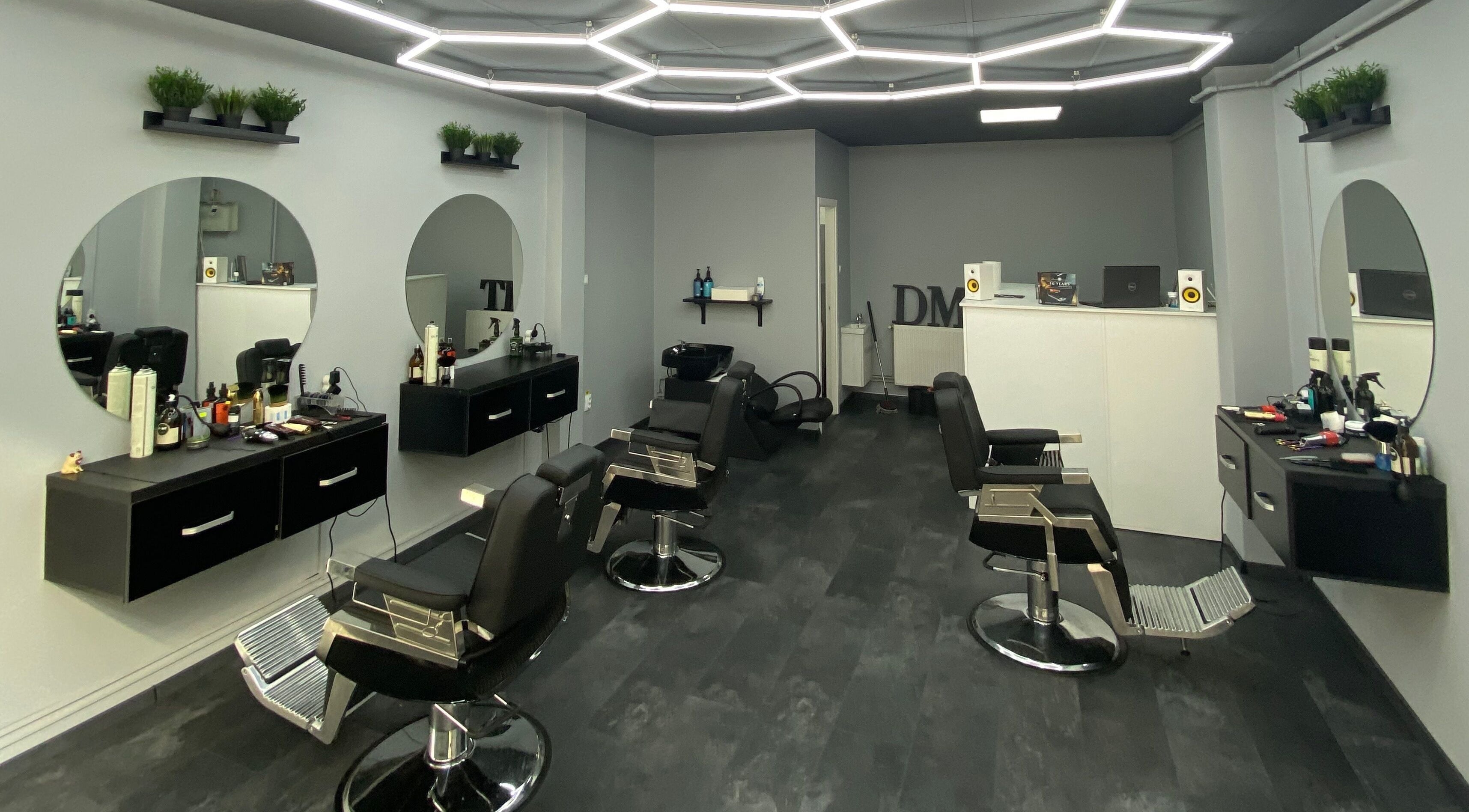 Interior modern și elegant la Damoti Barbershop, București, București, RO, cu oglinzi rotunde și scaune confortabile.