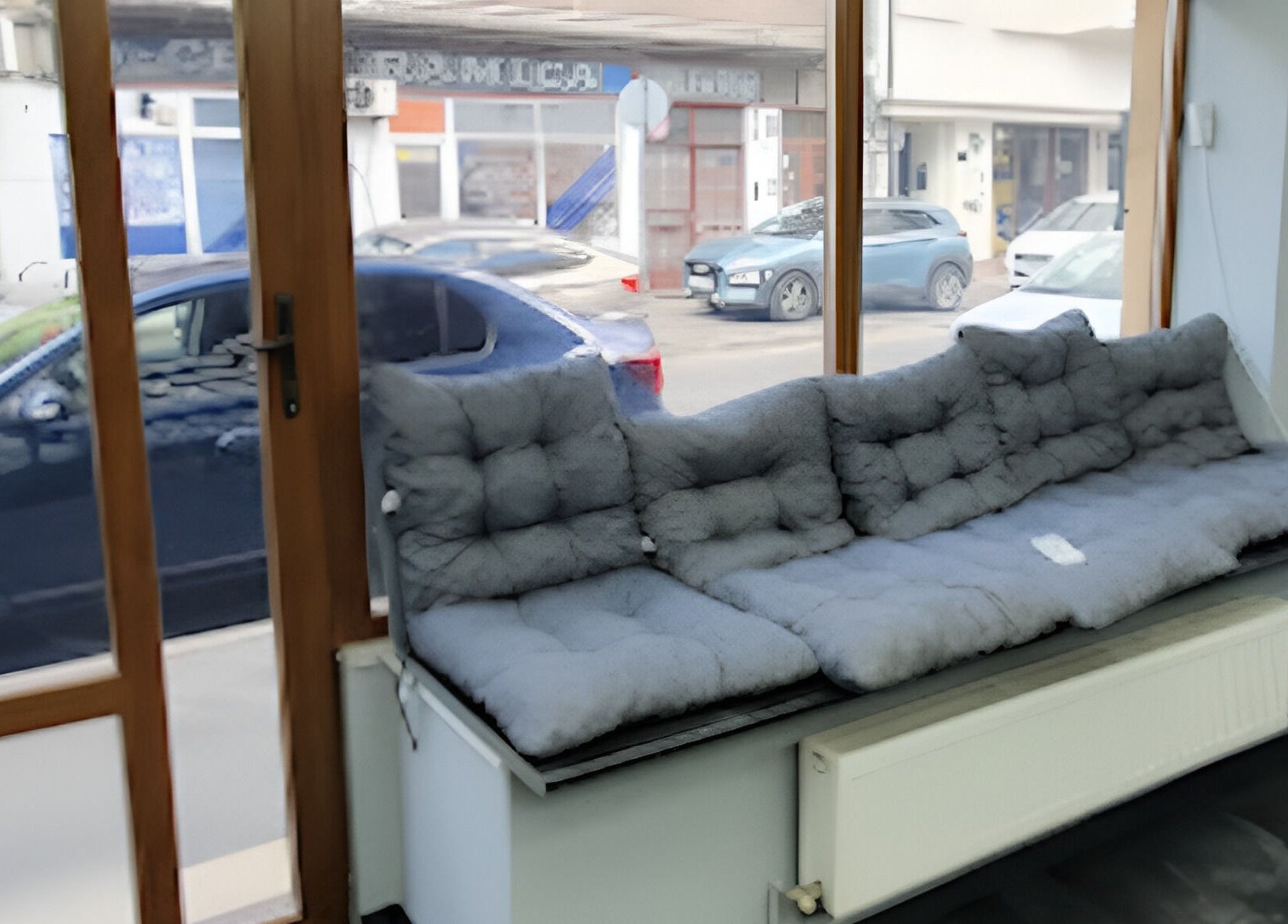 Zona de așteptare confortabilă la Damoti Barbershop, București, București, RO, cu canapea gri.