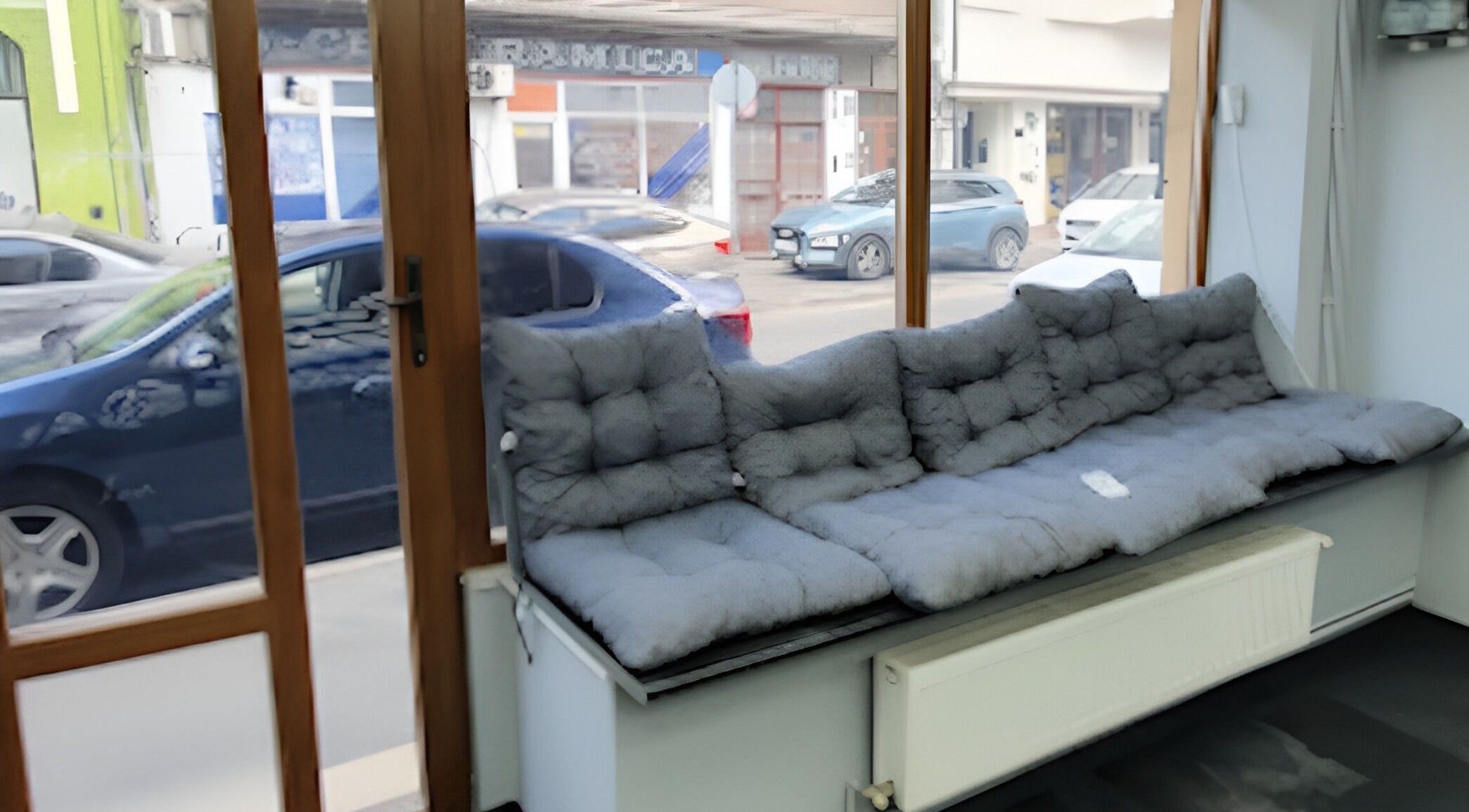 Zona de așteptare confortabilă la Damoti Barbershop, București, București, RO, cu canapea gri.