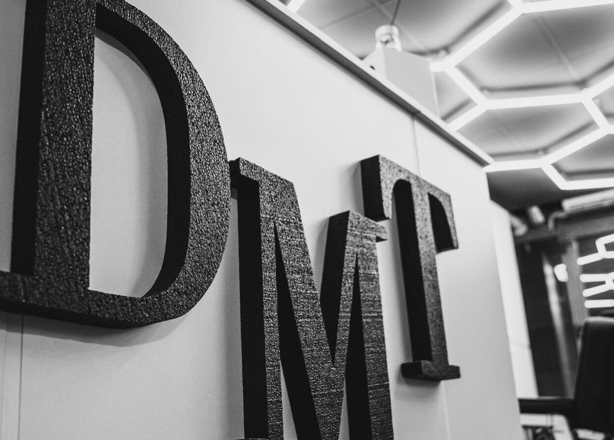 Intrare stilizată Damoti Barbershop din București, București, RO, cu litere geometrice moderne.