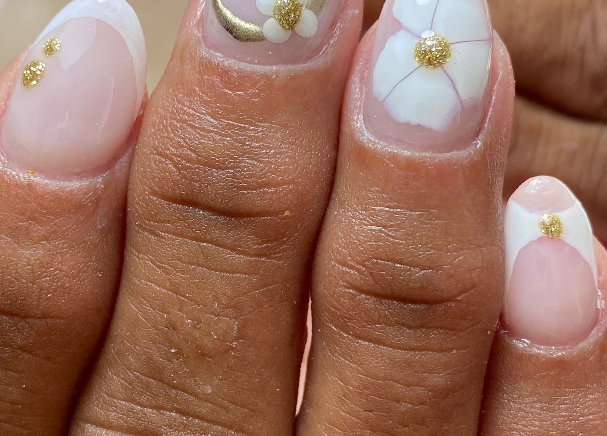 Diseño de uñas con flores doradas en Belleza Traslasierra, Córdoba, Córdoba, AR.