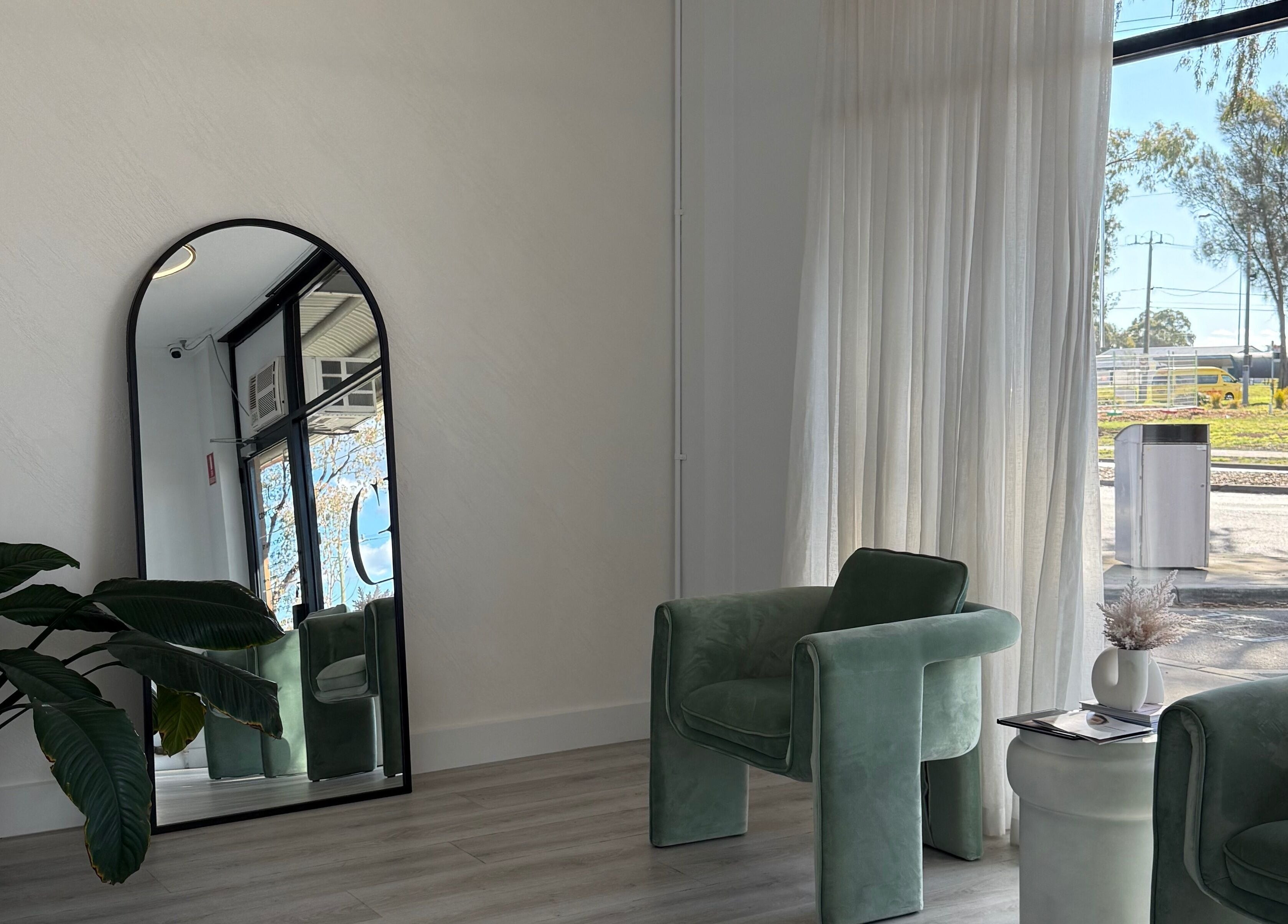 Chic waiting area at Cosmetic Effects, Ivanhoe, Victoria, AU, featuring lush plants and stylish seating.