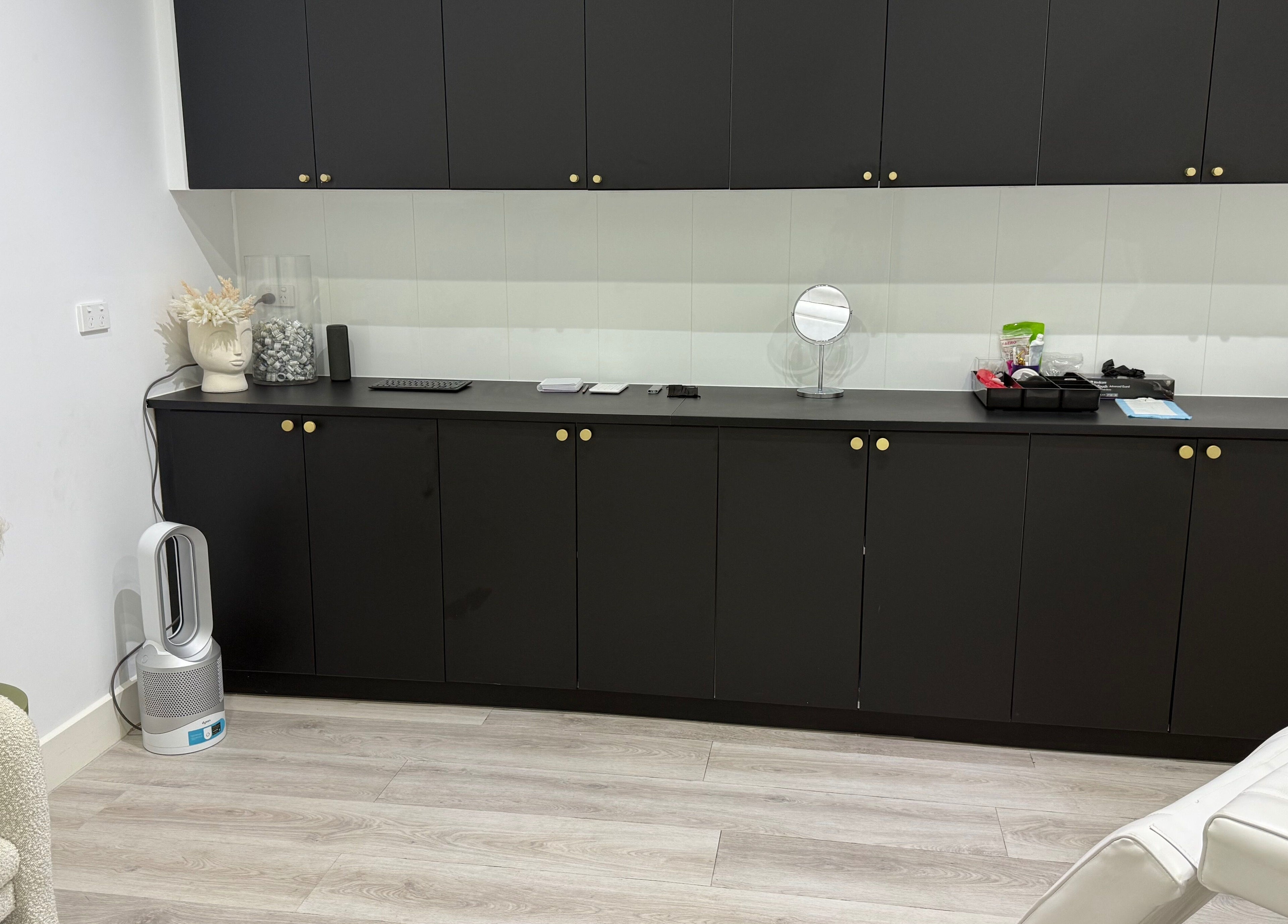 Modern treatment room at Cosmetic Effects, Ivanhoe, Victoria, AU, featuring sleek black cabinetry and decor.