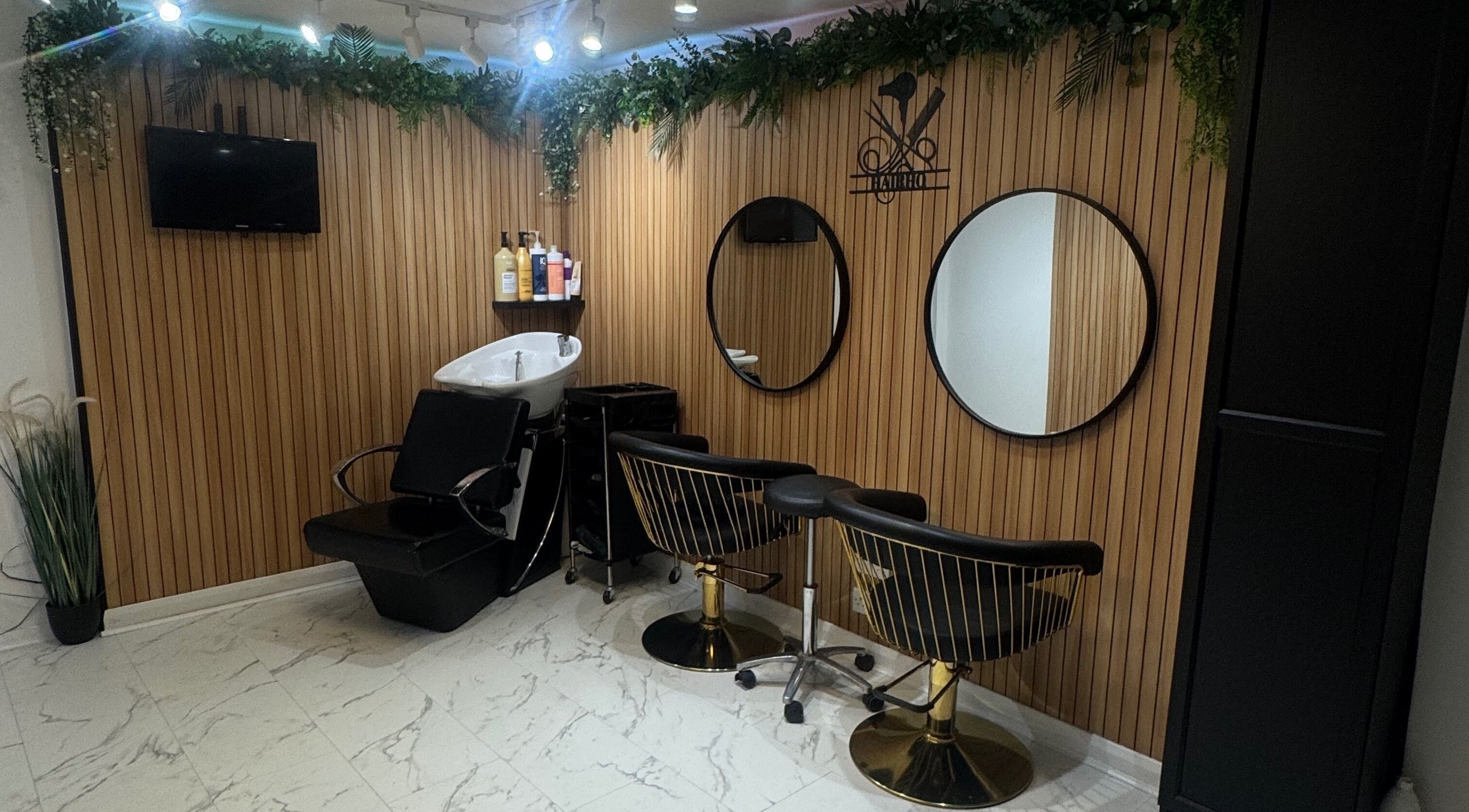 Elegant salon interior at HairHQ in Maidstone, England, GB showing washing station and mirrors.
