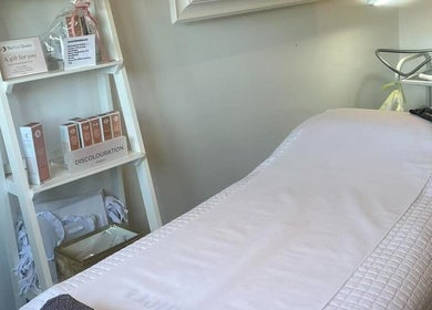 Peaceful treatment room at The Peel Queen in Addlestone, England, featuring a care product shelf and treatment bed.