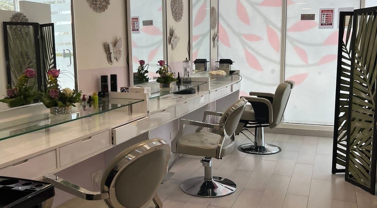 Elegant interior of Intime Ladies Salon, Dubai, featuring chic styling chairs and fresh florals.