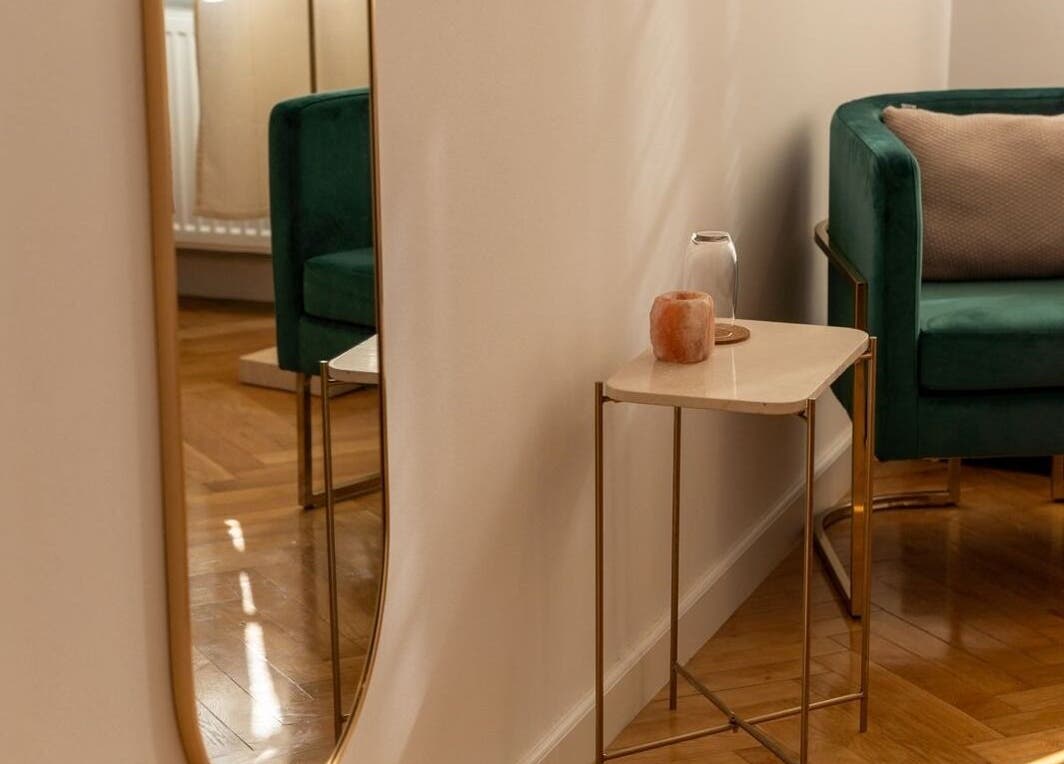 Cozy corner at Studio Masażu Ciało W Centrum Uwagi, Warszawa, Województwo Mazowieckie, PL. Features a green velvet chair.