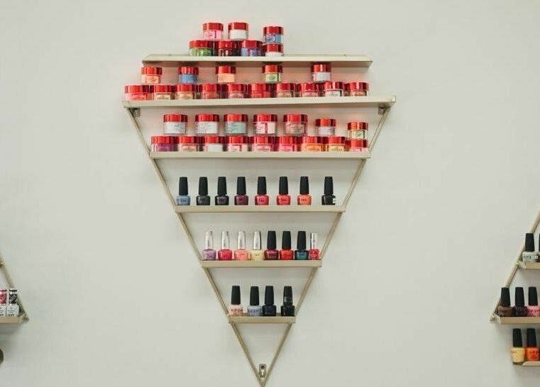 Nail polish and products neatly displayed on a triangle shelf at Supreme Nail Spa, Toronto, Ontario, CA.