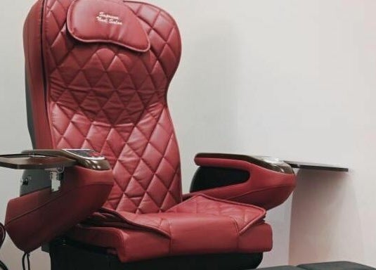 Red pedicure chair at Supreme Nail Spa in Toronto, Ontario, CA offering a luxurious spa experience.