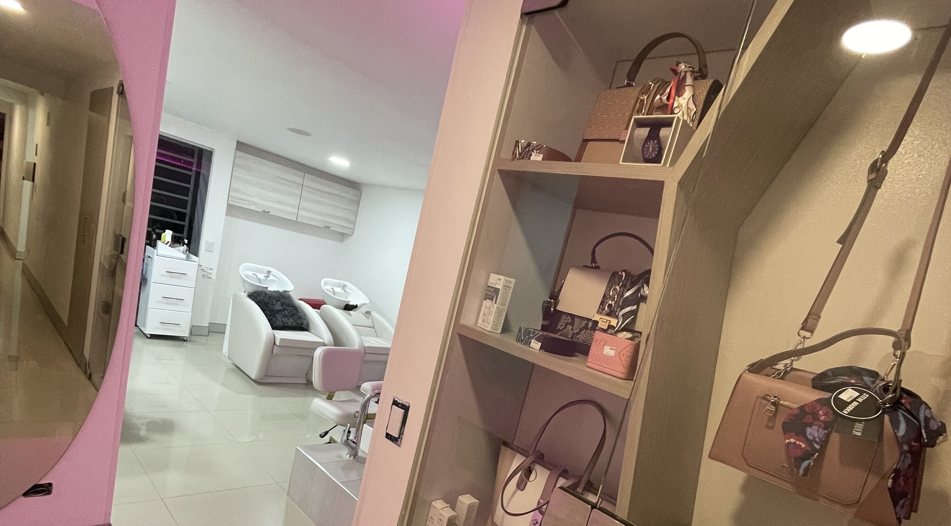 Interiores de lujo en Shift Experience, Cali, Valle del Cauca, CO. Salón con decoración moderna y estantería elegante.