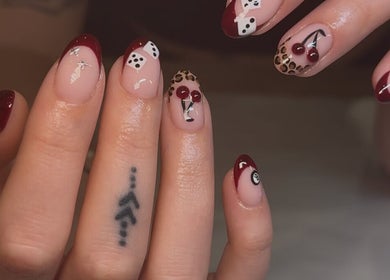 Stylish nail art featuring red tips and patterns at Keep It Cassie, Hucclecote, England, GB.