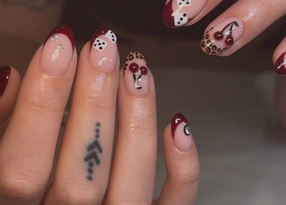 Stylish nail art featuring red tips and patterns at Keep It Cassie, Hucclecote, England, GB.