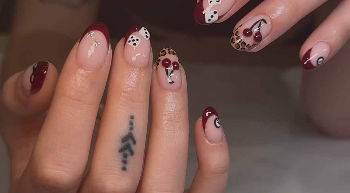 Stylish nail art featuring red tips and patterns at Keep It Cassie, Hucclecote, England, GB.