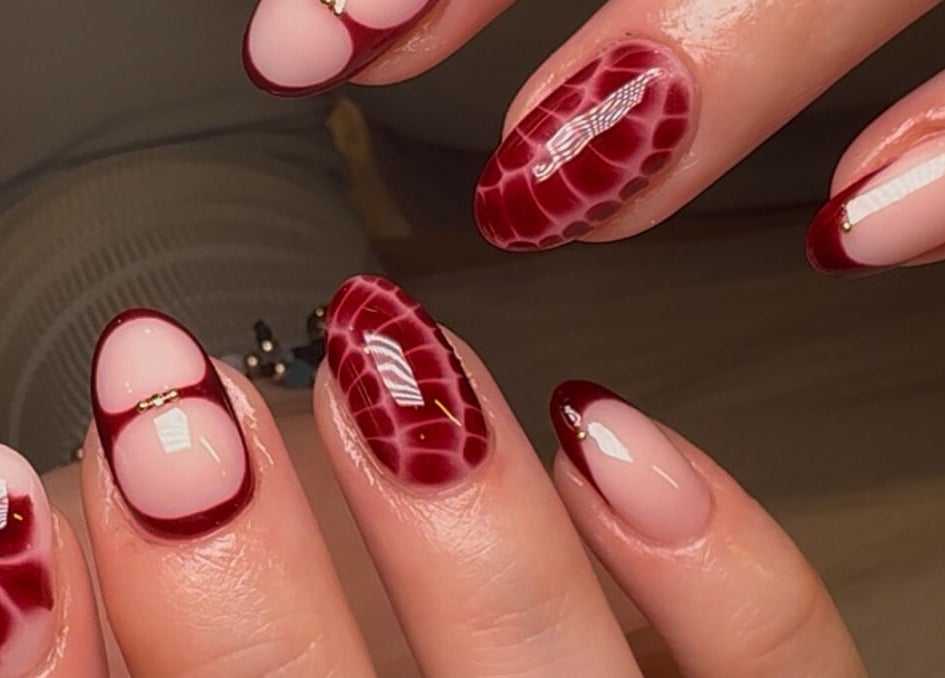 Elegant nail art at Keep It Cassie, Hucclecote, England, GB showcasing intricate red designs.