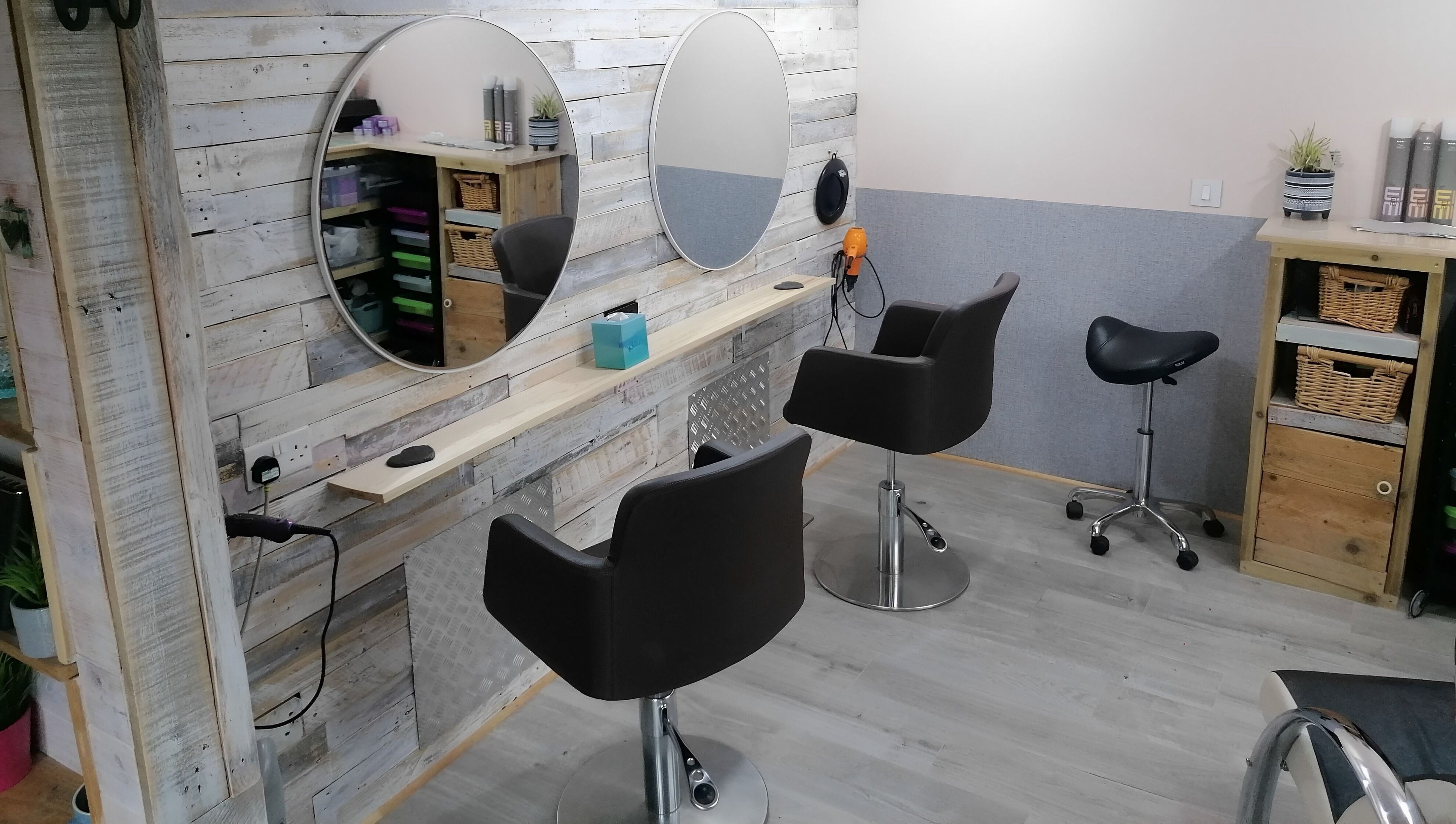 Elegant styling area with chic chairs at The Colourbox Hair Salon, Indian Queens, England, GB.