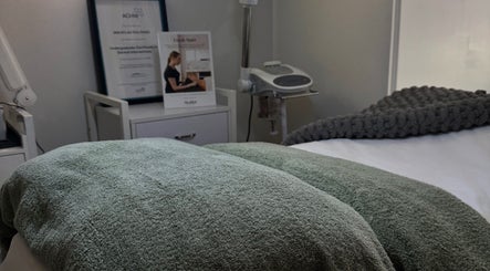 Calm treatment room at BARE SSKIN, Melbourne, Victoria, AU featuring soft bedding and modern equipment.