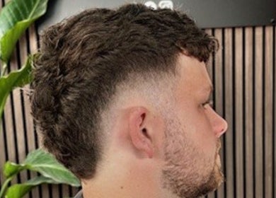 Close-up of a stylish fade haircut at RM Barbering in Stockton-on-tees, England, GB with greenery backdrop.