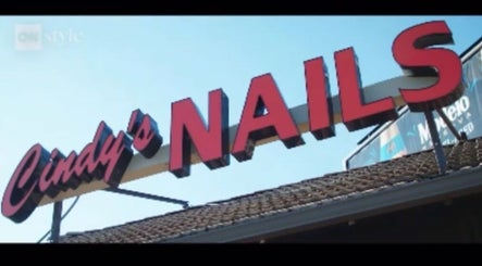 Bold sign of Cindy's Nails in Denver, Colorado, US against a clear blue sky.