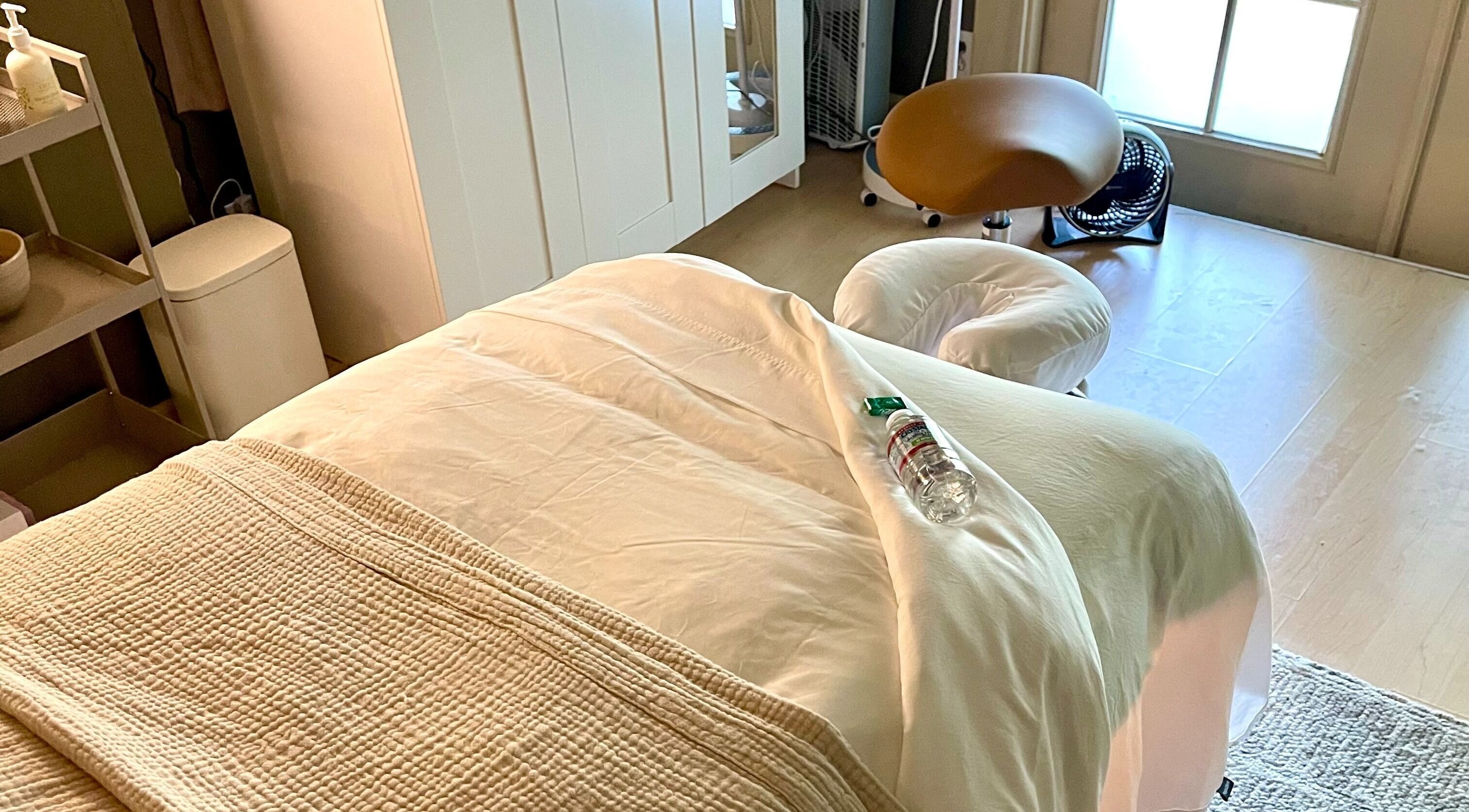 Relaxing massage room at The June Massage and Skin Studio, Monroe, Washington, US, featuring a comfy treatment bed.