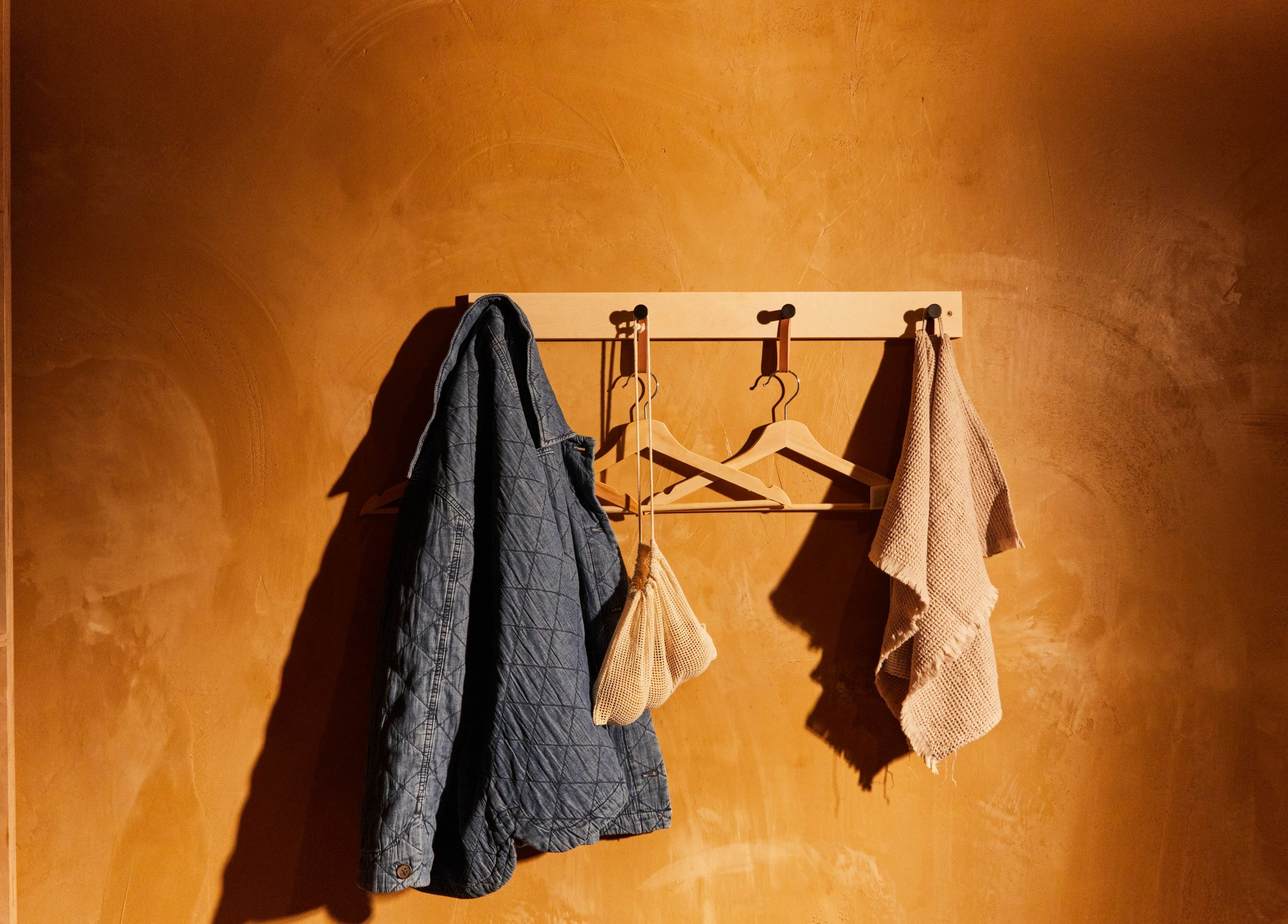 Coat and towels hang on wall in Bodied, London, England, GB wellness venue showcasing a warm, inviting space.