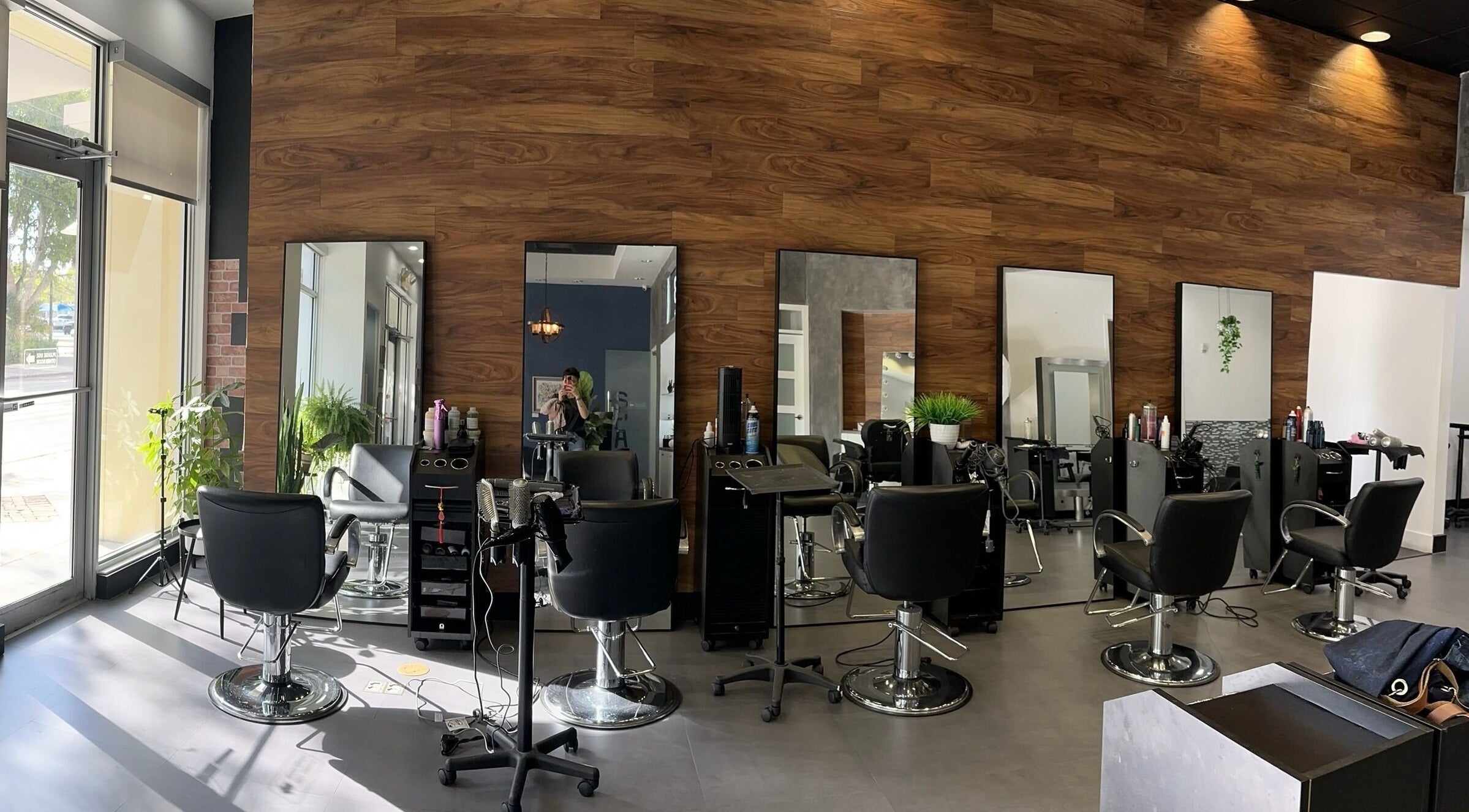 Interior of NEW by CARO RIBEIRO in South Miami, Florida, US, featuring sleek salon chairs and modern decor.