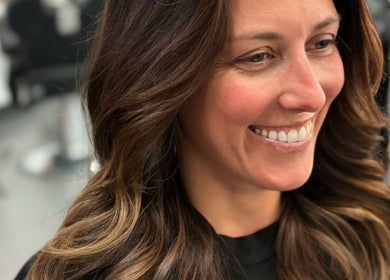 Smiling client showcases stunning hairstyle at NEW by CARO RIBEIRO in South Miami, Florida, US.