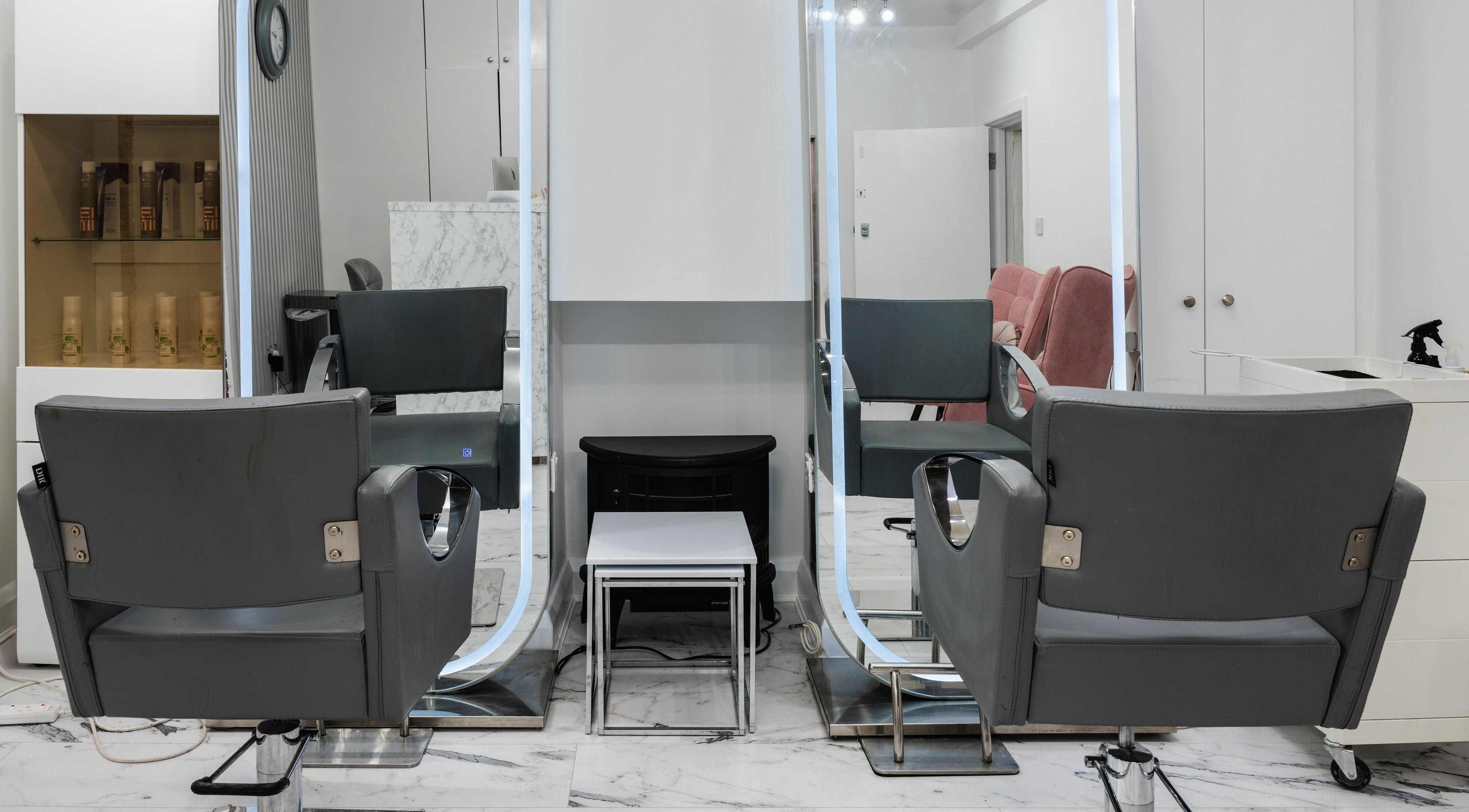 Elegant salon mirror and chairs at Brazilian Glam in London, England, GB showcasing modern styling.