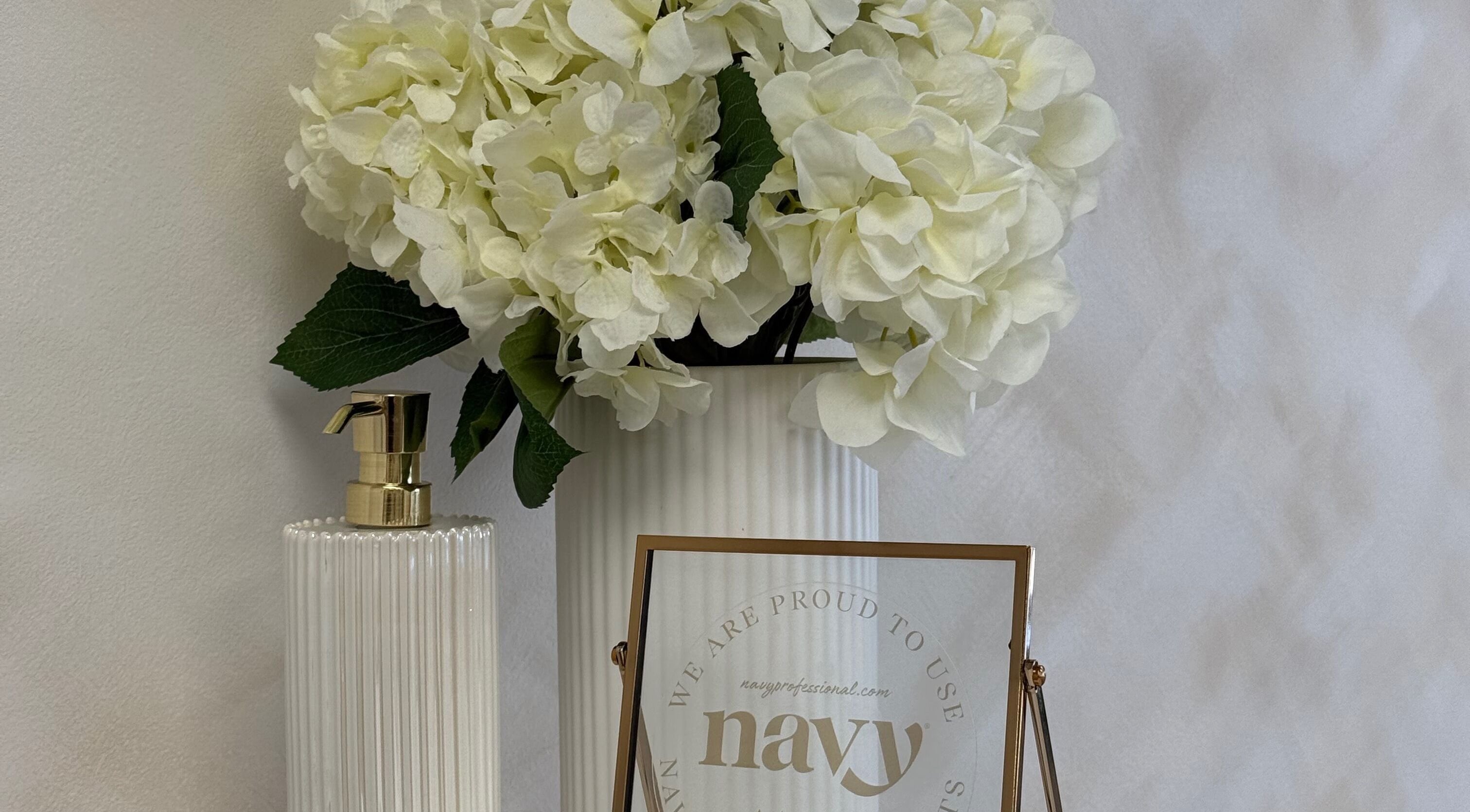 Elegant decor at Olive Nails Studio, Kilmarnock, Scotland with white flowers and a stylish soap dispenser.